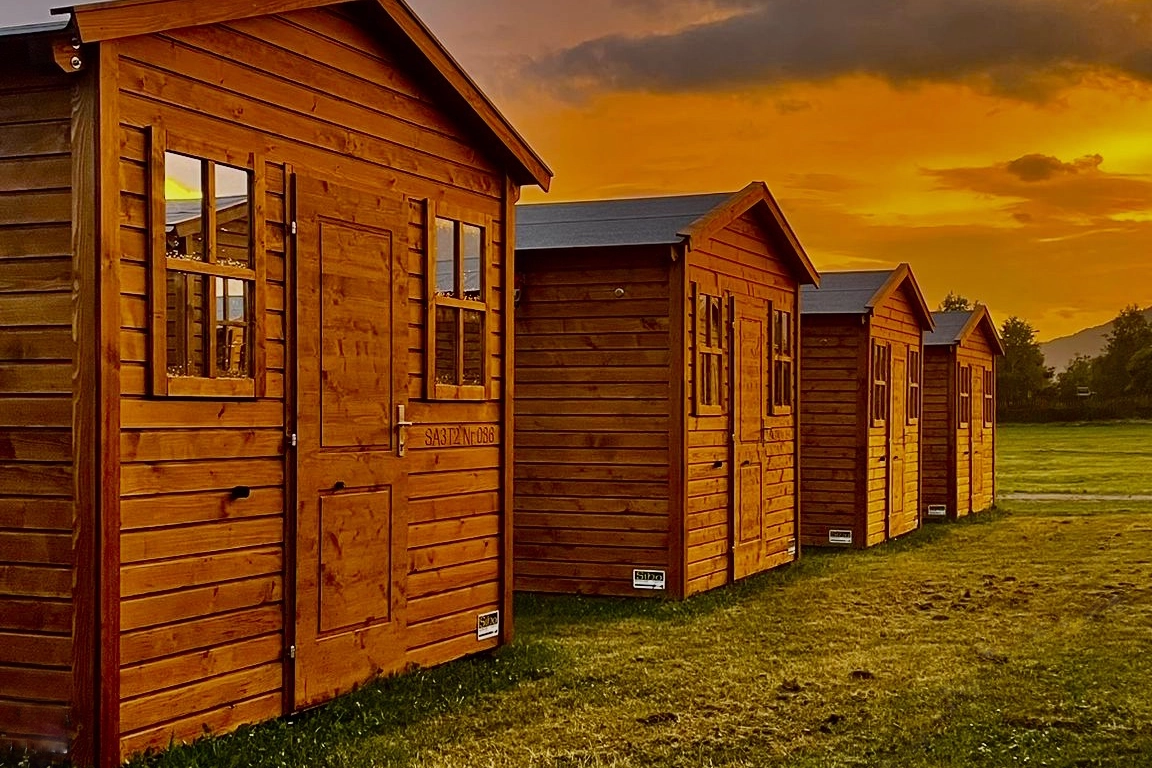 Schöne Holz-Chalets für ein besonders relaxtes Glampingerlebnis bei F1, MotoGP und AirPower.